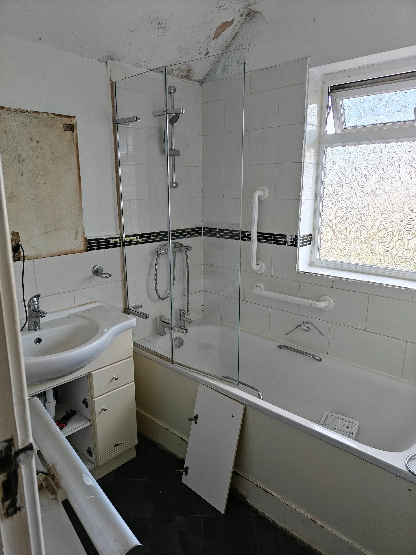 Before: a dated bathroom with an old shower bath, worn vanity unit and tired tiling