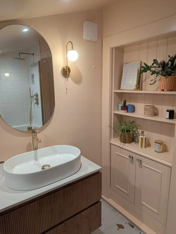 Warm bathroom with wood shelving and round mirror