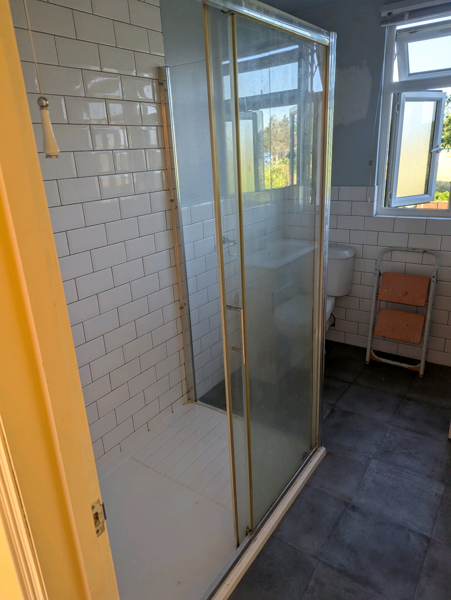 Before: Dated gold-framed shower enclosure with frosted glass