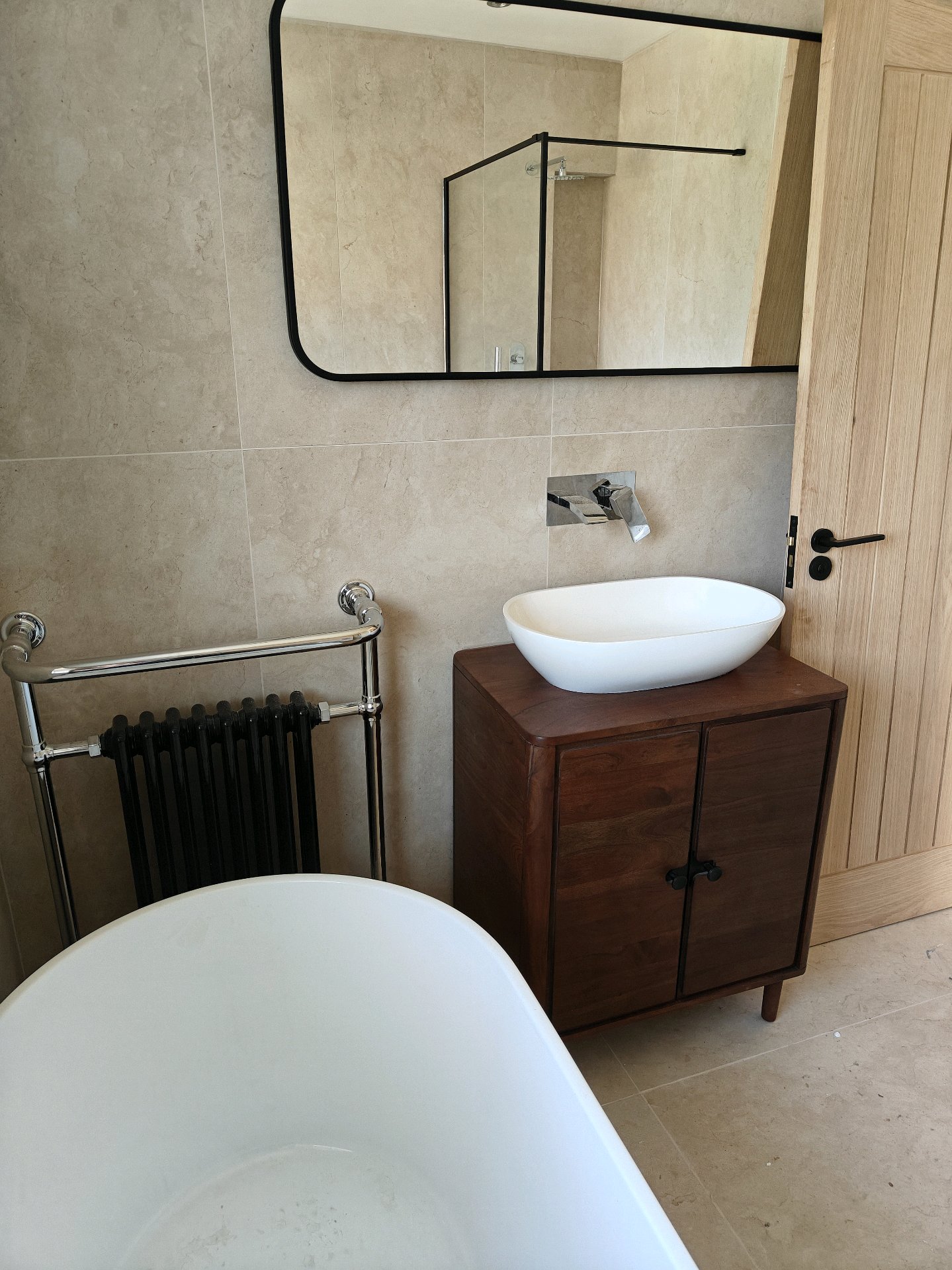 Wooden vanity unit with vessel basin and black-framed mirror